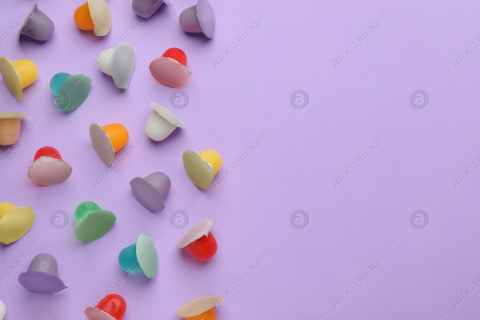 Photo of Tasty bright jelly cups on violet background, flat lay. Space for text
