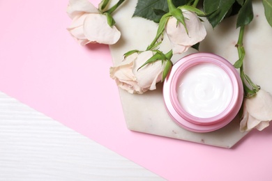 Photo of Skin care product and flowers on color background, flat lay. Space for text
