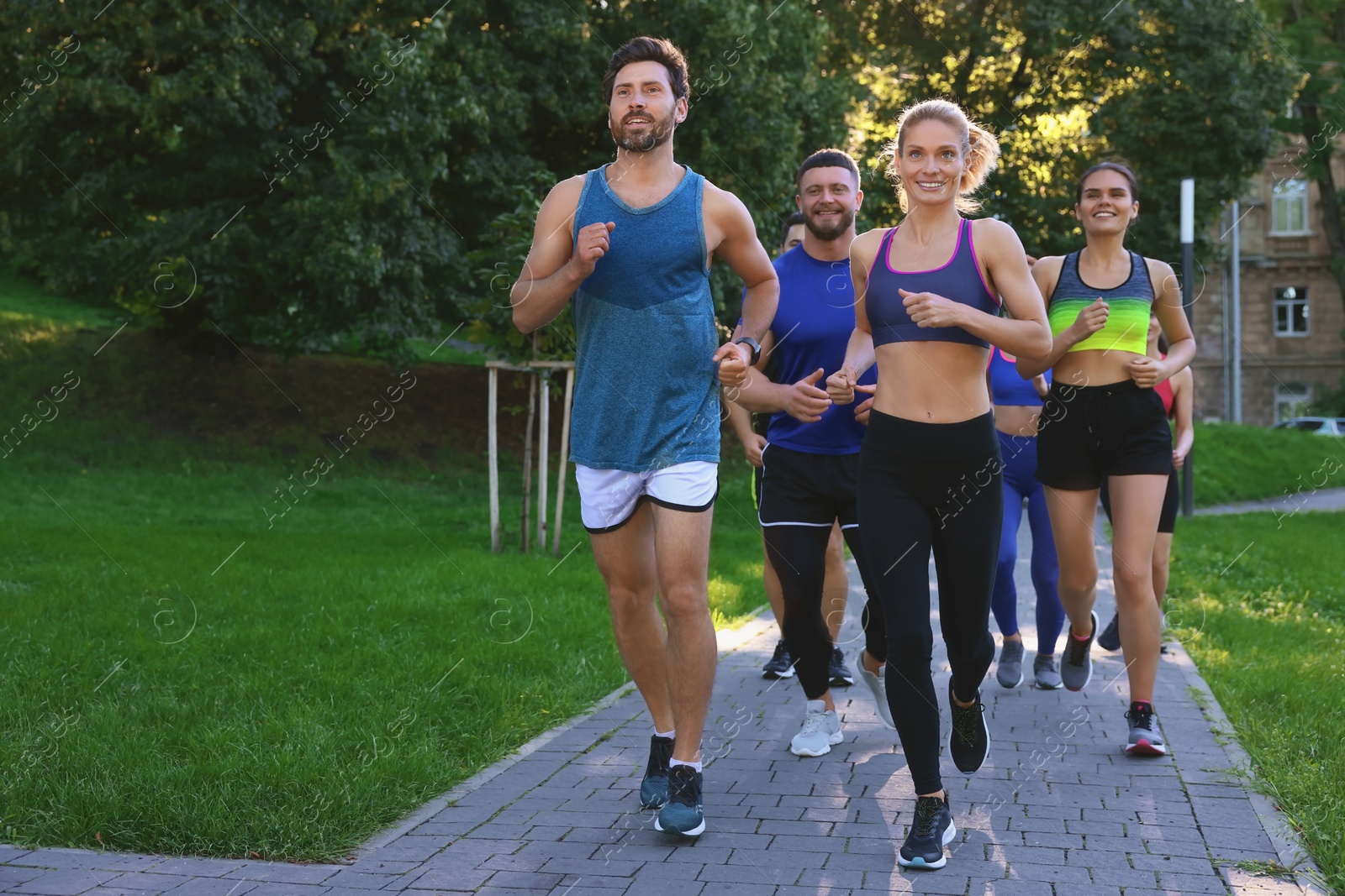 Photo of Group of people running in park. Space for text