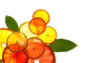 Photo of Illuminated slices of citrus fruits and leaves on white background, top view