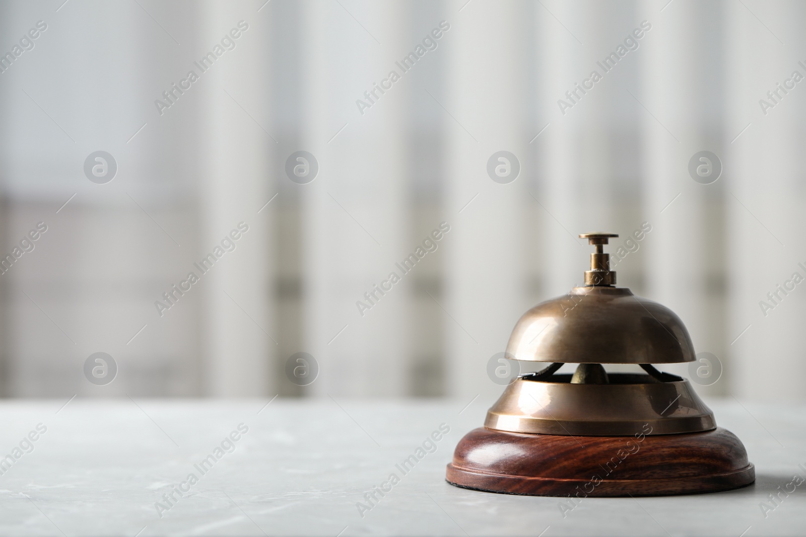 Photo of Hotel service bell on table indoors, closeup. Space for text