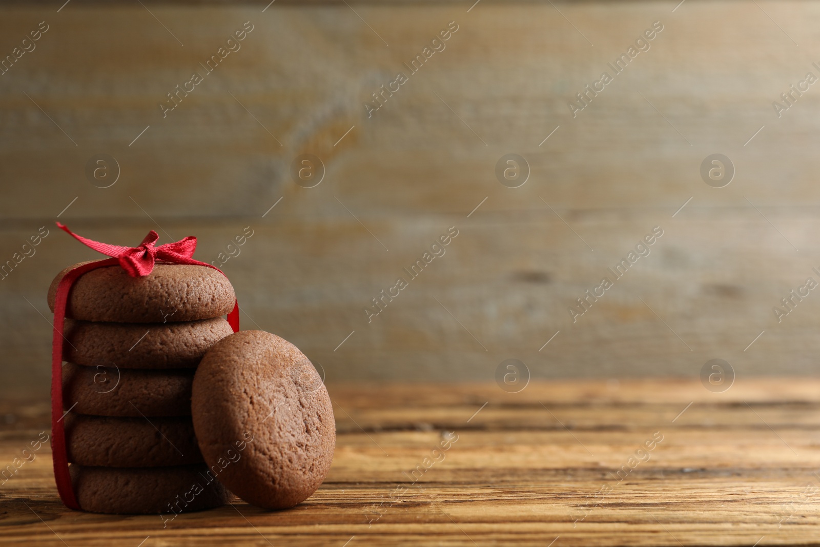 Photo of Tasty homemade chocolate cookies on wooden table. Space for text