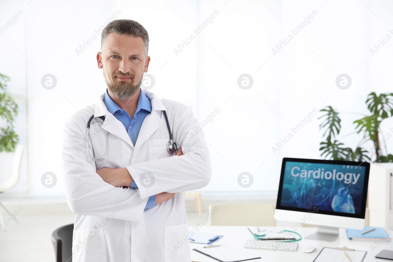 Photo of Portrait of male doctor in coat at workplace in clinic. Cardiology center