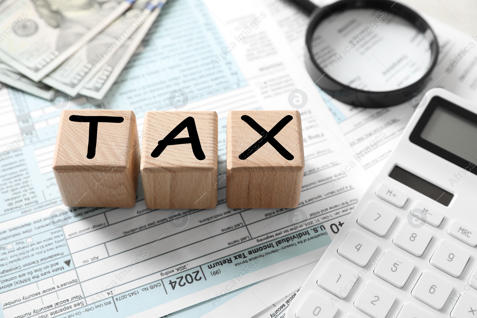 Photo of Wooden cubes with word Tax and calculator on documents, closeup