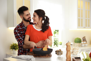 Lovely young couple cooking together in kitchen