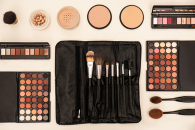 Flat lay composition with with tools and cosmetic on professional makeup artists workplace