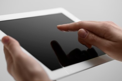 Photo of Closeup view of woman using modern tablet on light grey background