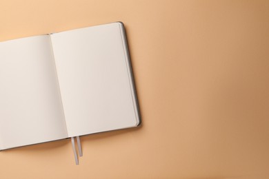 Blank notebook on beige background, top view. Space for text