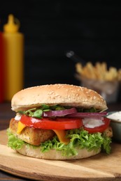 Photo of Delicious burger with tofu and fresh vegetables on wooden board