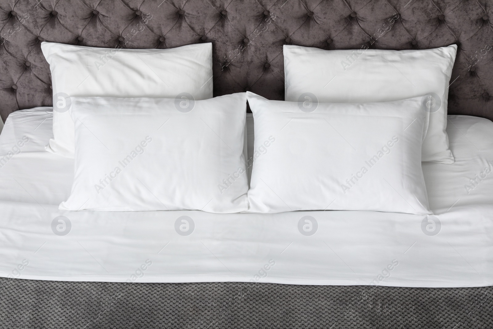 Photo of Soft white pillows on comfortable bed, closeup