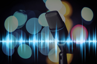 Image of Microphone and radio wave on dark background, bokeh effect