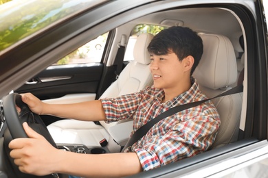 Male driver with fastened safety belt in car