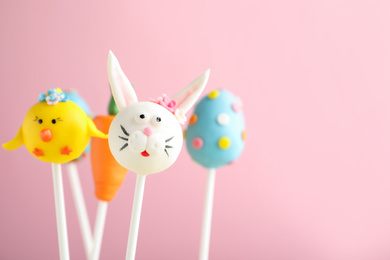 Photo of Delicious sweet cake pops on light pink background, space for text. Easter holiday