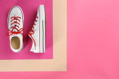 Photo of Pair of trendy sneakers on pink background, flat lay. Space for text