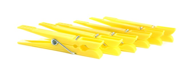 Photo of Bright yellow plastic clothespins on white background