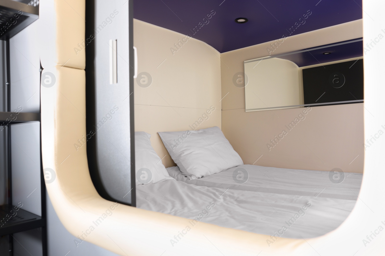 Photo of Capsule with twin bed in modern pod hostel. Stylish interior