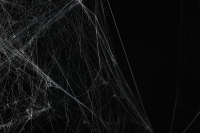 Photo of Creepy white spider web on black background