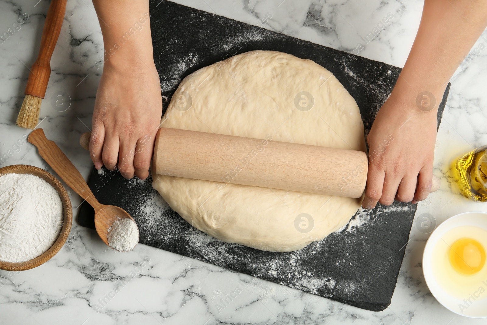Photo of Female baker preparing bread dough at kitchen table, flat lay