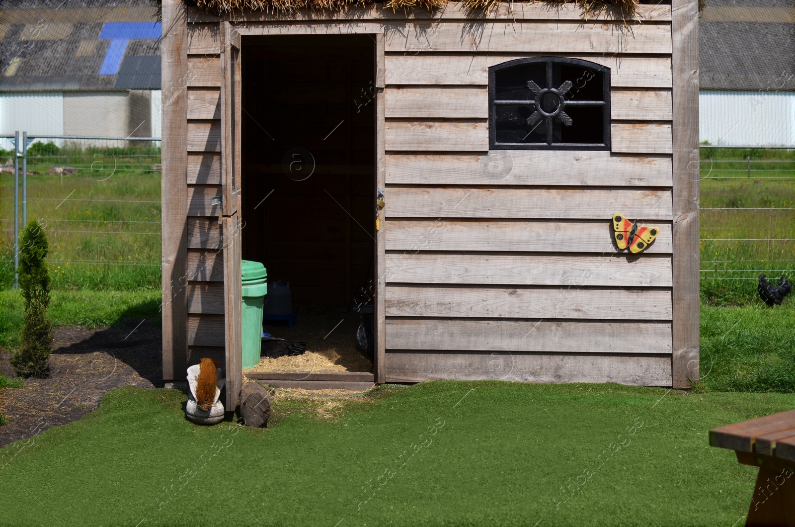 Photo of Wooden chicken coop outdoors on sunny day