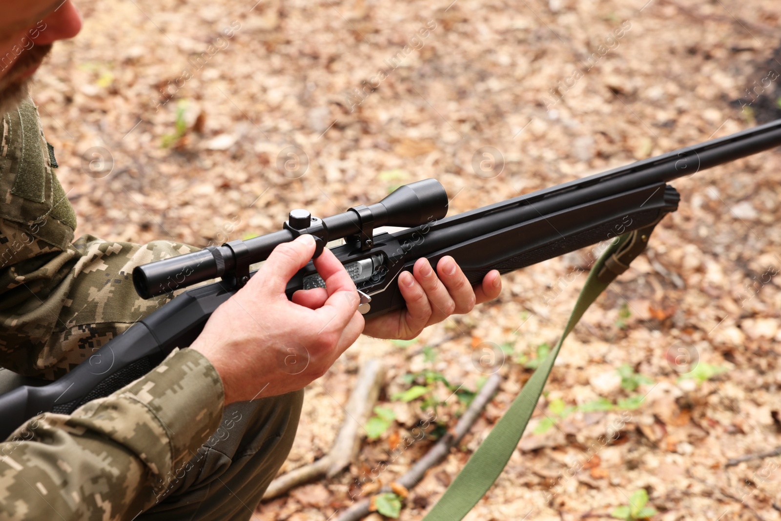 Photo of Man with hunting rifle wearing camouflage outdoors, closeup