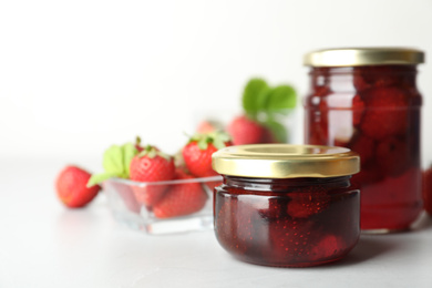 Photo of Delicious pickled strawberry jam and fresh berries on light table. Space for text