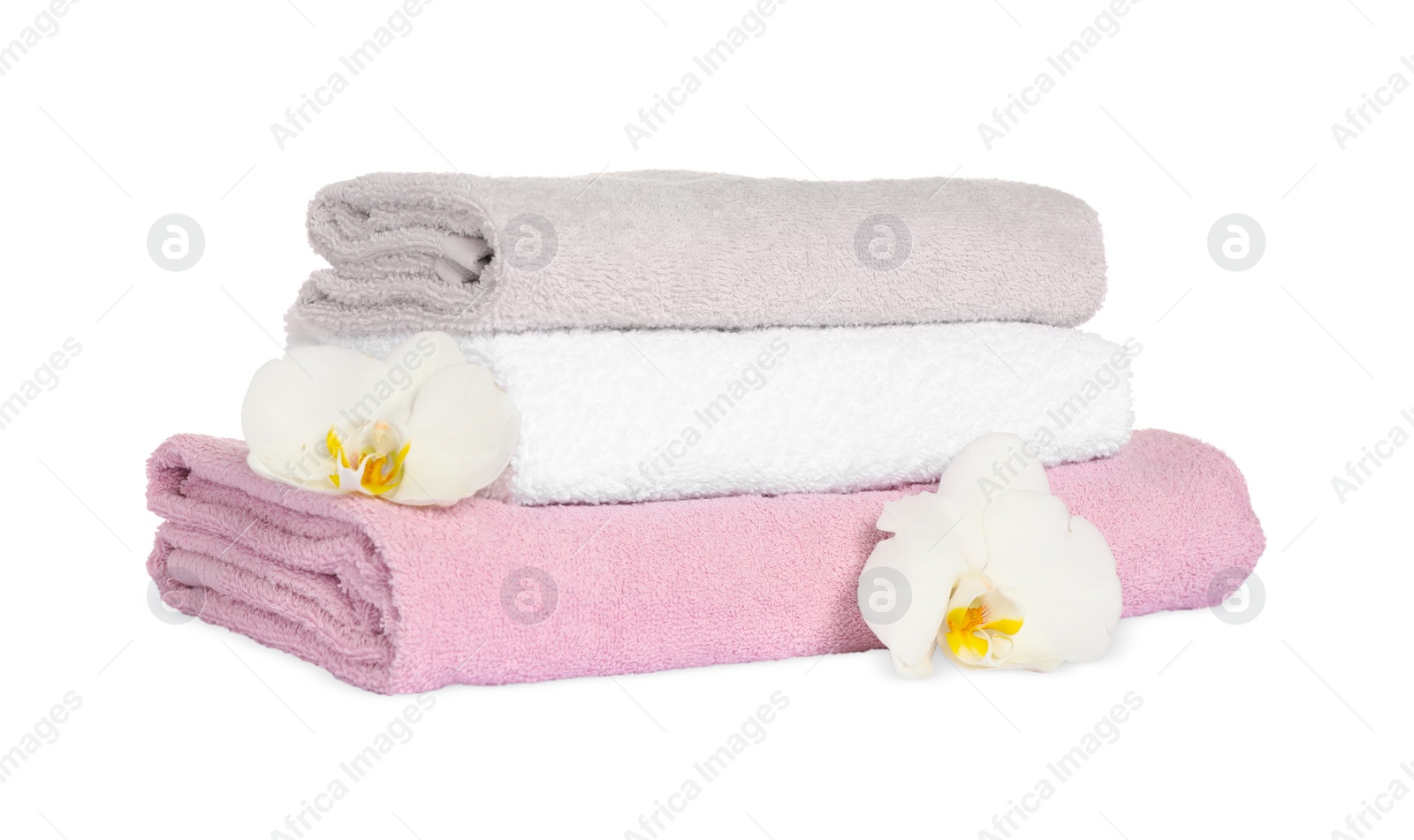 Photo of Stack of clean soft towels with orchids isolated on white