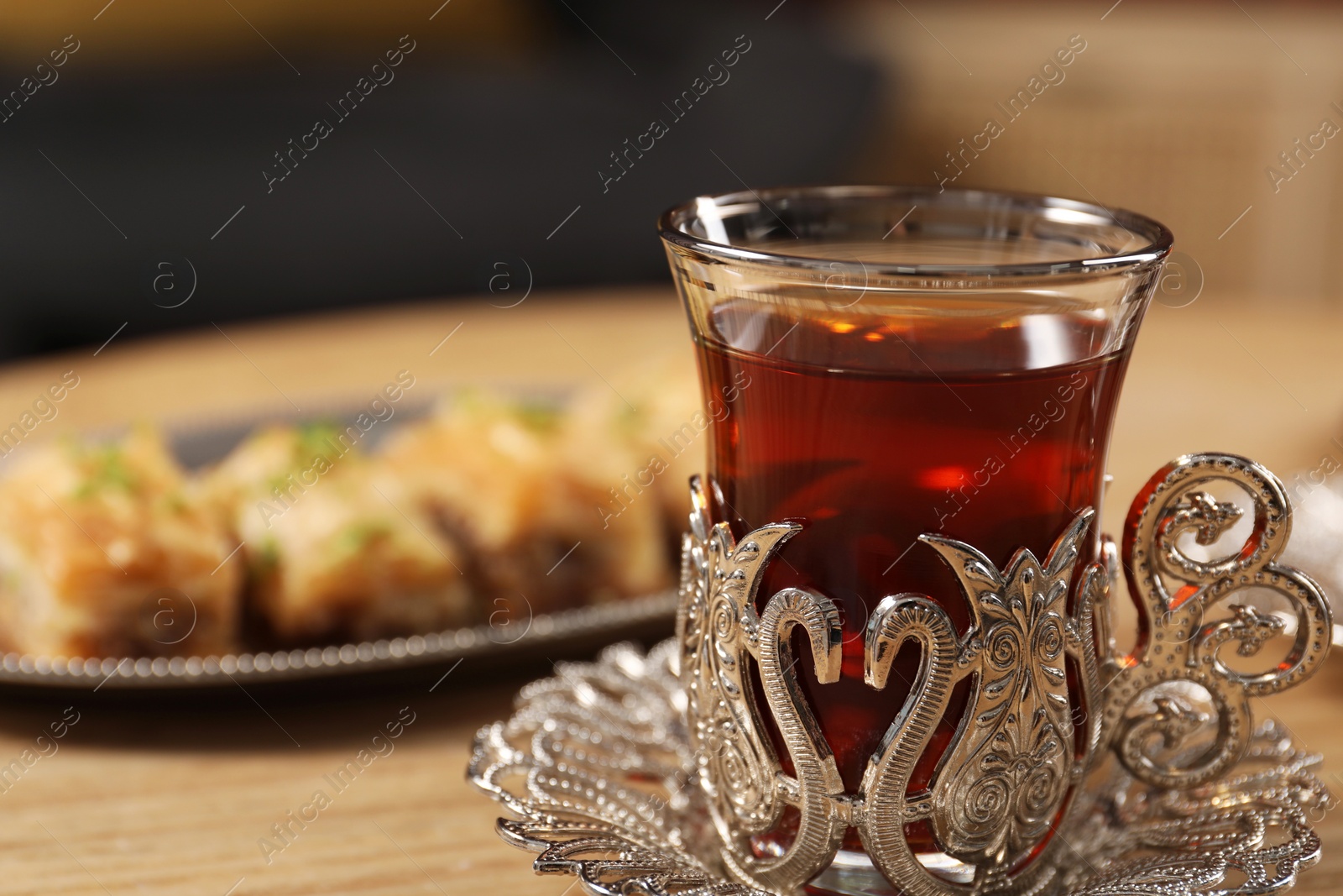 Photo of Glass of traditional Turkish tea in vintage holder on table, closeup. Space for text