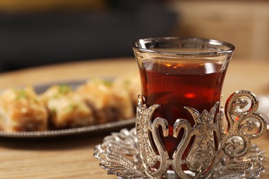 Glass of traditional Turkish tea in vintage holder on table, closeup. Space for text