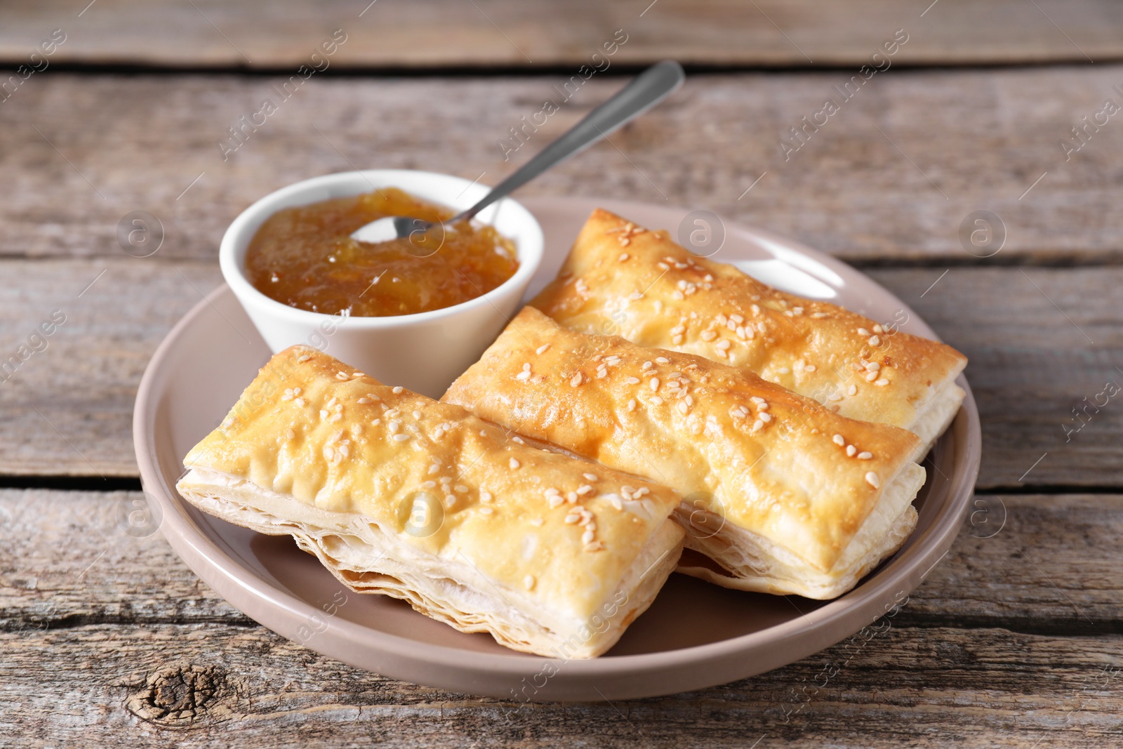 Photo of Delicious puff pastry served on wooden table, closeup