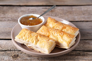 Delicious puff pastry served on wooden table, closeup