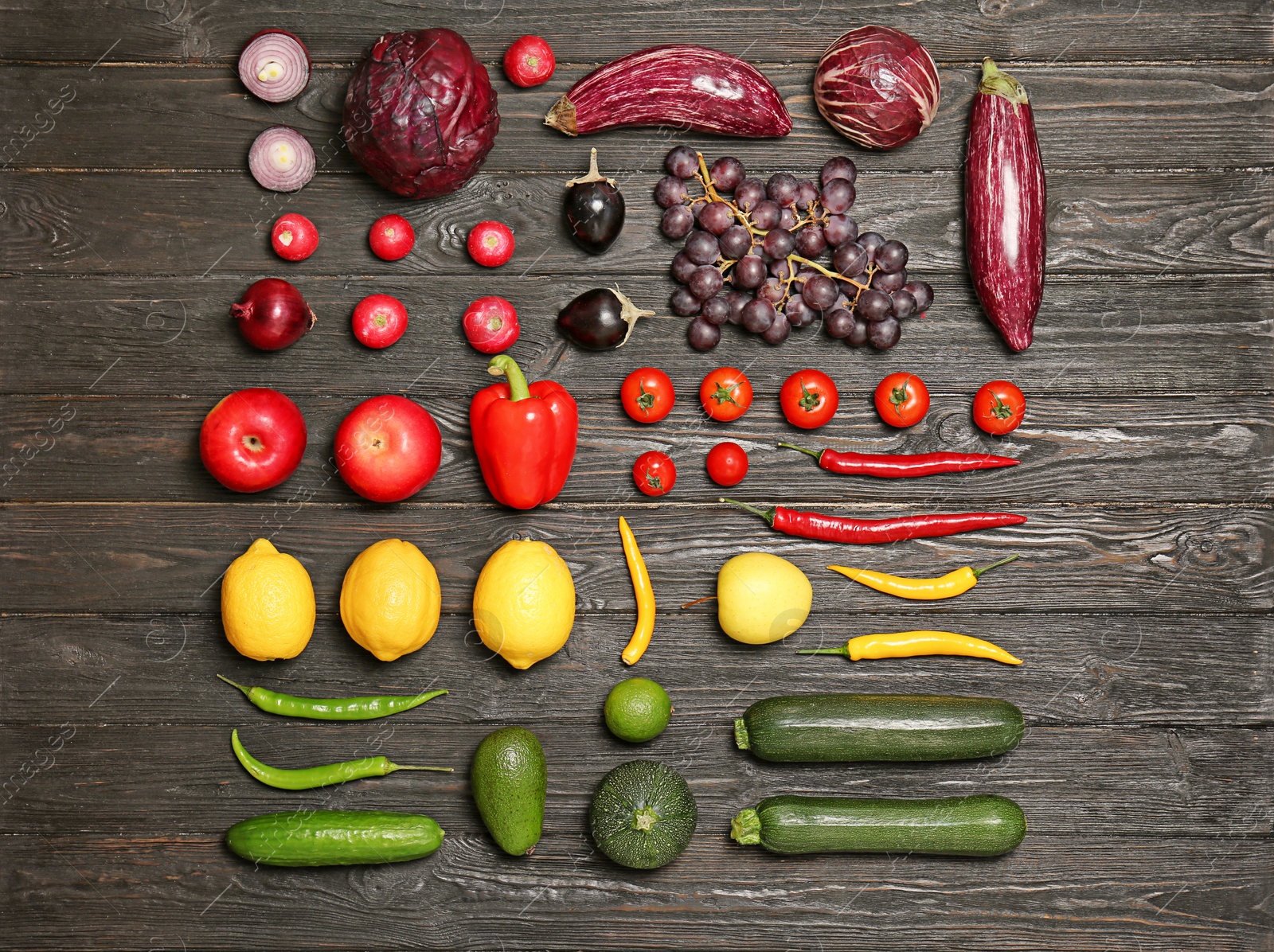 Photo of Rainbow collection of ripe fruits and vegetables on wooden background, top view