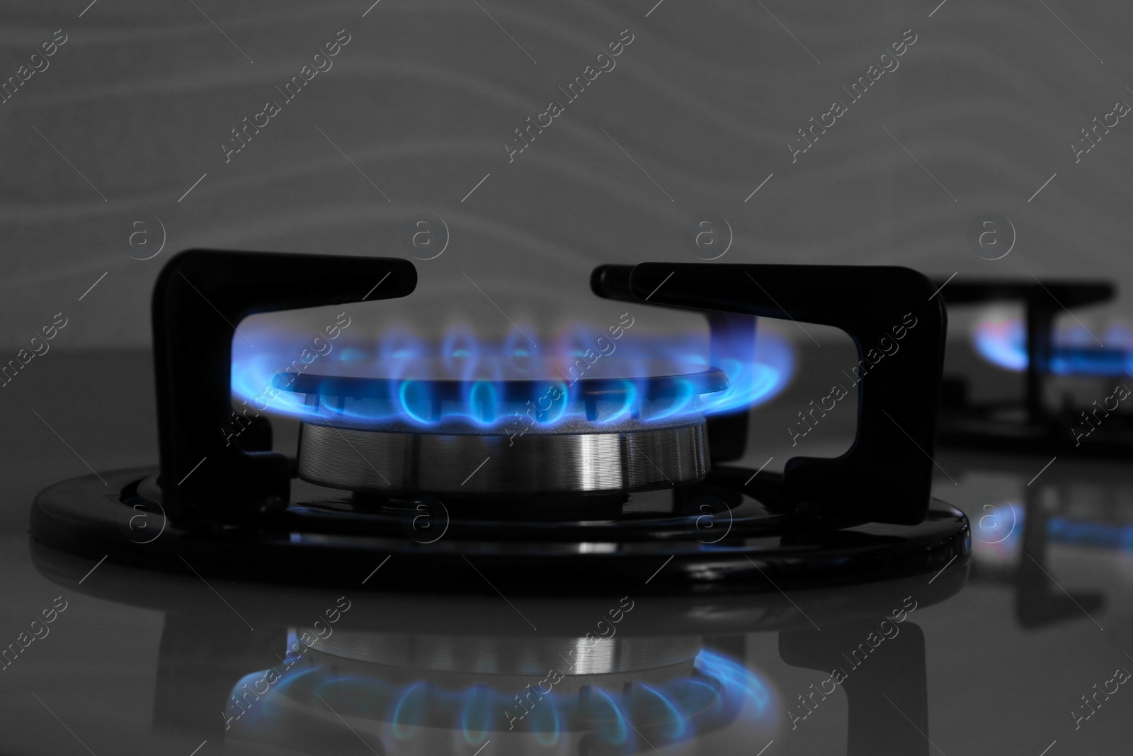 Photo of Gas burner of modern stove with burning blue flame