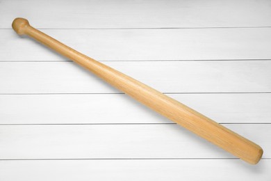 Photo of Baseball bat on white wooden table, top view. Sports equipment