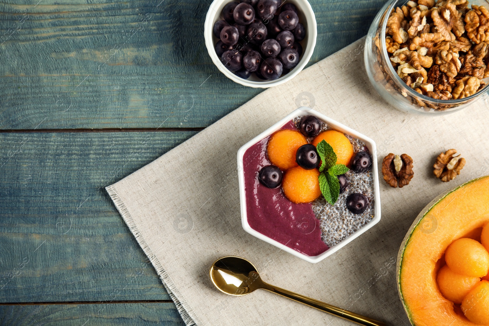 Photo of Flat lay composition with bowl of tasty acai smoothie on wooden table