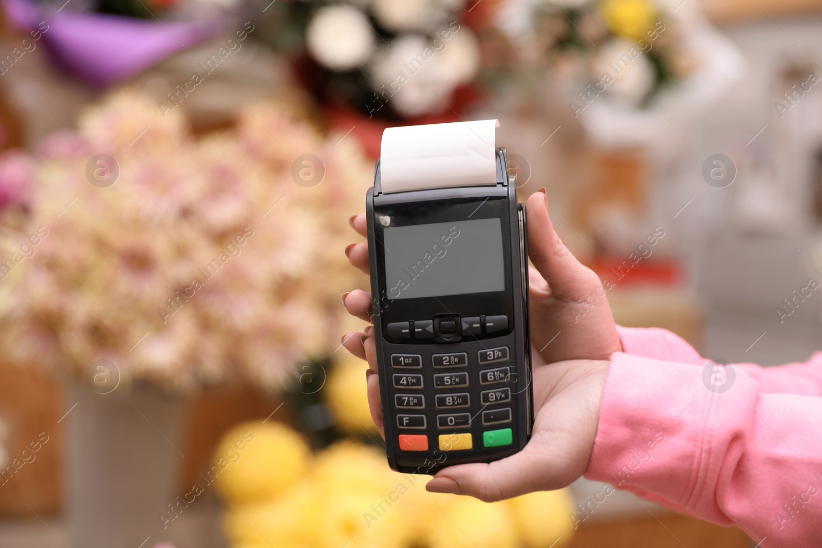 Photo of Woman holding payment terminal in floral shop, closeup. Space for text