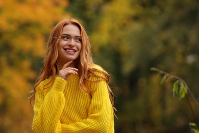 Portrait of happy woman in autumn park. Space for text