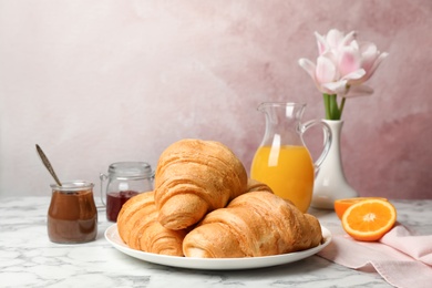 Photo of Tasty croissants served for breakfast on table