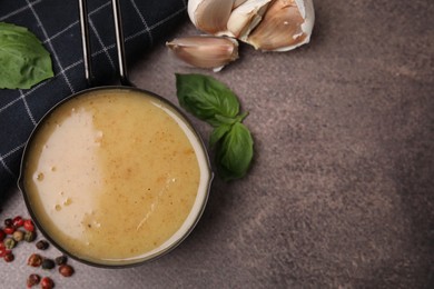 Photo of Delicious turkey gravy, basil, peppercorns and garlic on brown textured table, flat lay. Space for text