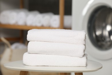 Photo of Folded soft terry towels on white table in bathroom, closeup