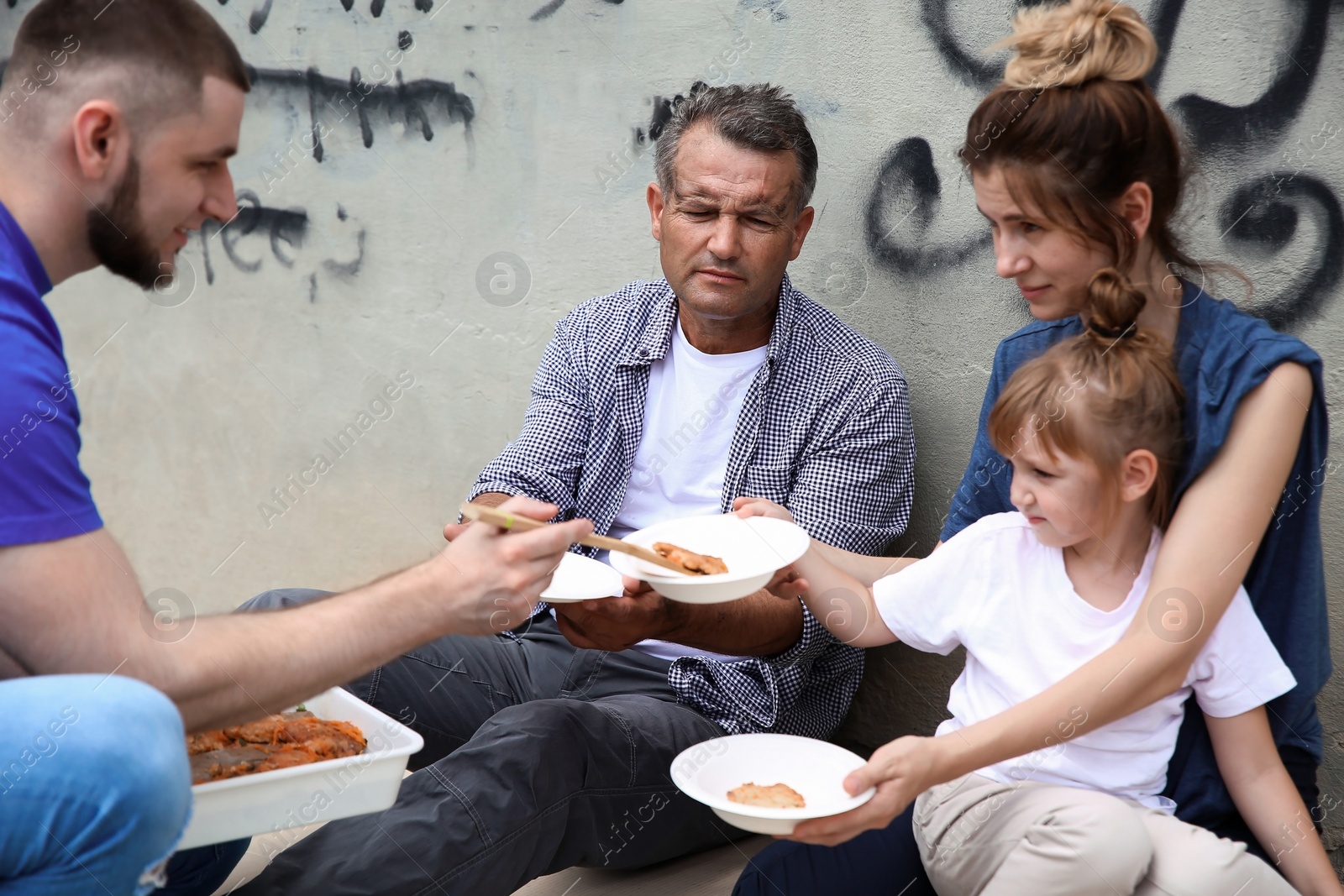 Photo of Poor people receiving food from volunteer outdoors