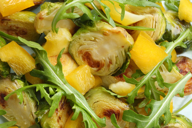 Photo of Delicious salad with roasted Brussels sprouts on plate, top view