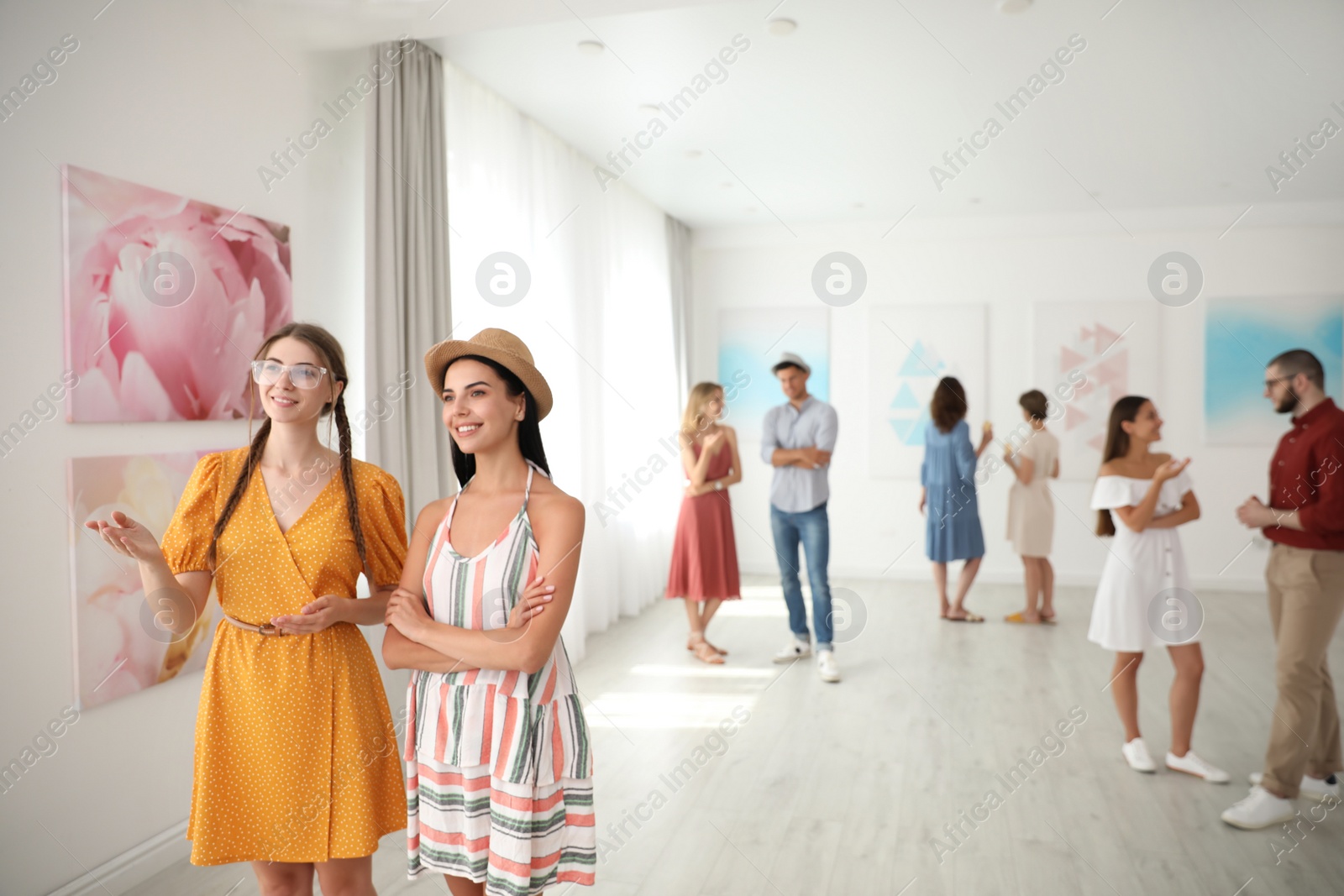 Photo of Young women at exhibition in art gallery