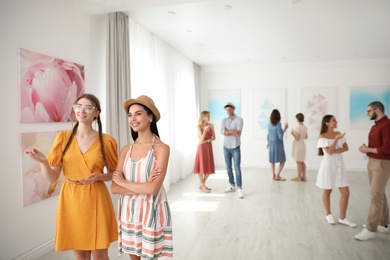 Photo of Young women at exhibition in art gallery