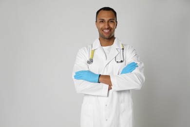 Photo of Doctor or medical assistant (male nurse) in uniform with stethoscope on light grey background