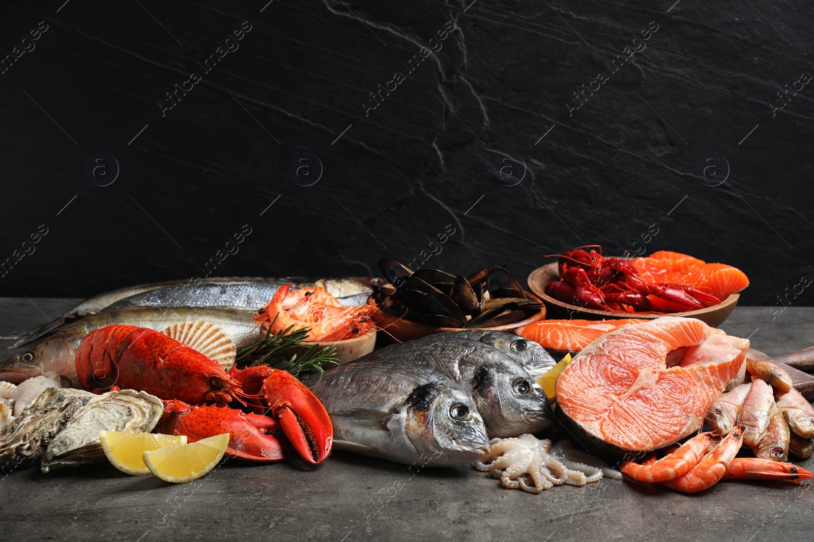 Photo of Fresh fish and different seafood on grey table