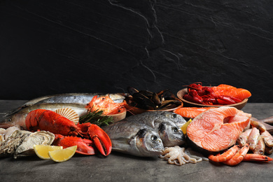 Fresh fish and different seafood on grey table