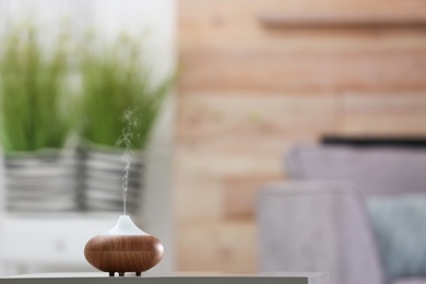 Photo of Aroma oil diffuser lamp on table against blurred background