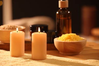 Photo of Spa composition with burning candles and personal care products on soft light surface, closeup