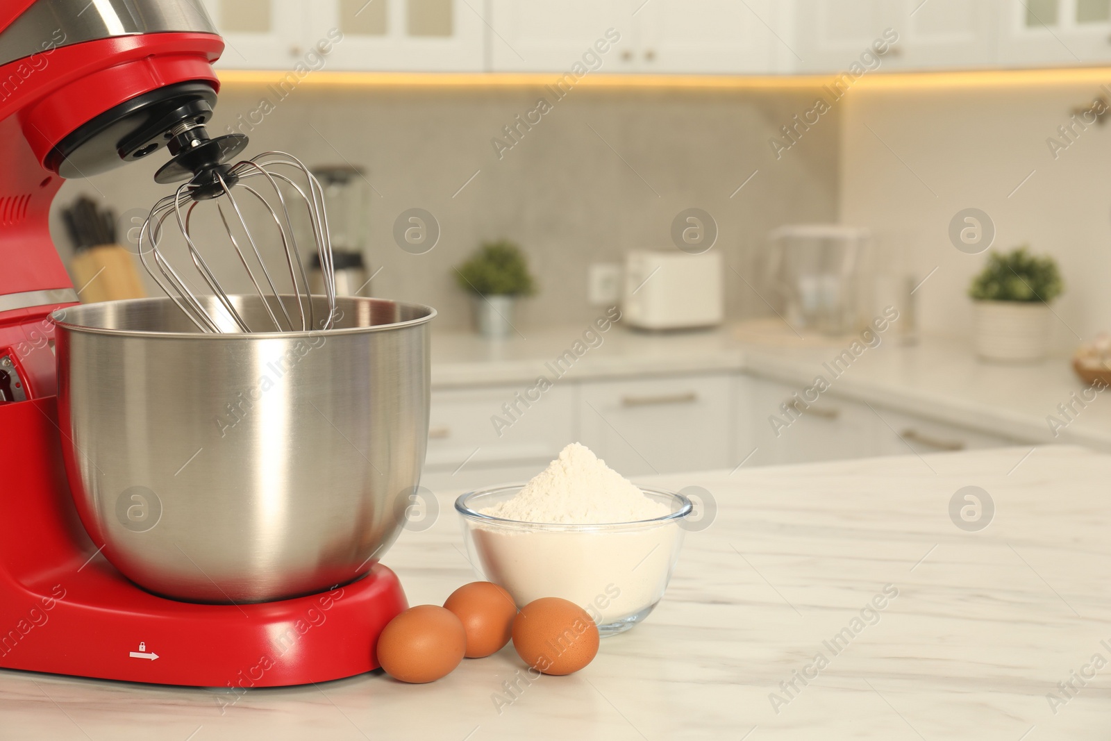 Photo of Modern red stand mixer, eggs and bowl with flour on white marble table in kitchen, space for text