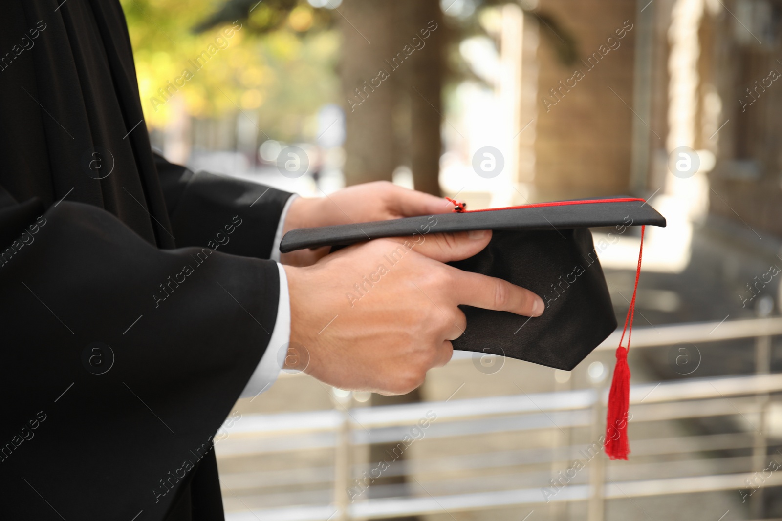 Photo of Student with graduation hat outdoors on sunny day, closeup